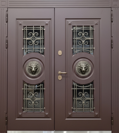 Равностворчатая входная термодверь с ковкой, стеклами и чеканкой «голова льва» (отделка МДФ коричневого цвета) Равностворчатая входная термодверь с ковкой, стеклами и чеканкой «голова льва» (отделка МДФ коричневого цвета)
